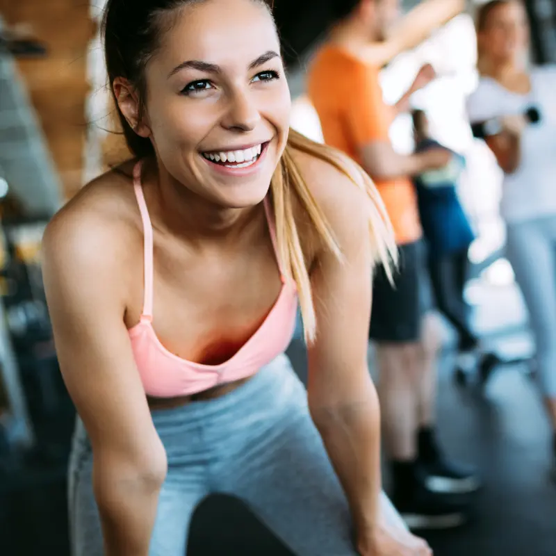 Eine junge Frau lächelt nach einem erfolgreichen Training